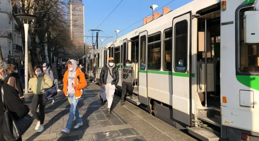 Des passagers attendent le tram à Nantes, profitant d'un week-end ensoleillé.