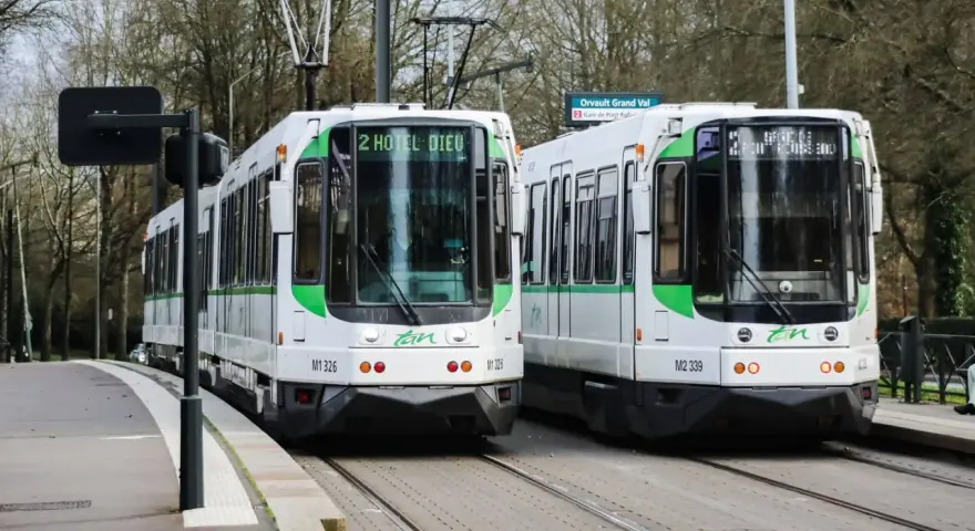 Deux trams blancs et verts de la Tan à Nantes, prêts à offrir un transport nantes gratuit. Ligne 2 vers Hôtel Dieu et Orvault Grand Val.