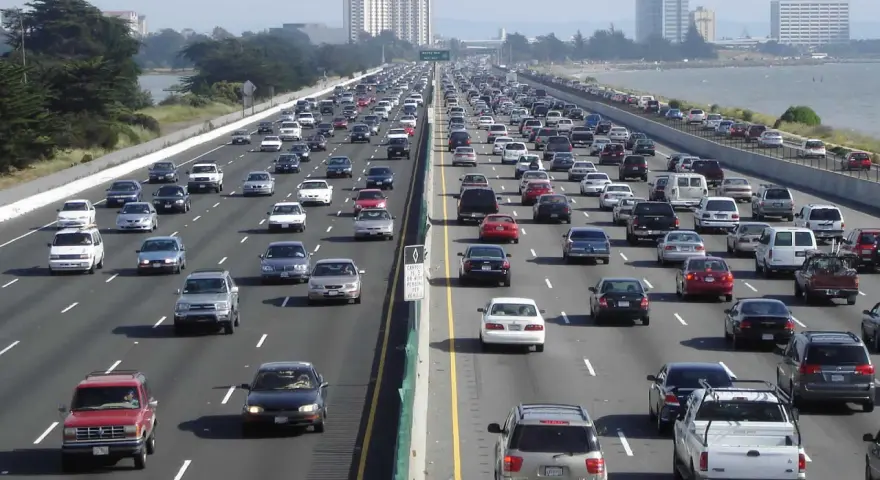 Embouteillage sur une autoroute de Los Angeles, avec des voitures sur plusieurs voies sous un ciel clair.