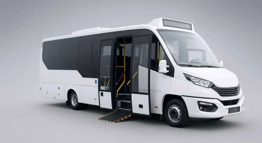 Minibus blanc avec rampe d'accès déployée, prêt à accueillir des passagers. Sa conception optimisée offre une grande capacité car pour le transport de groupe.