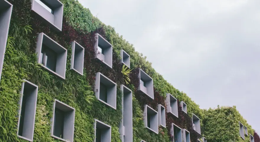 Un bâtiment végétalisé avec des fenêtres carrées, incarnant la définition d'une ville durable.