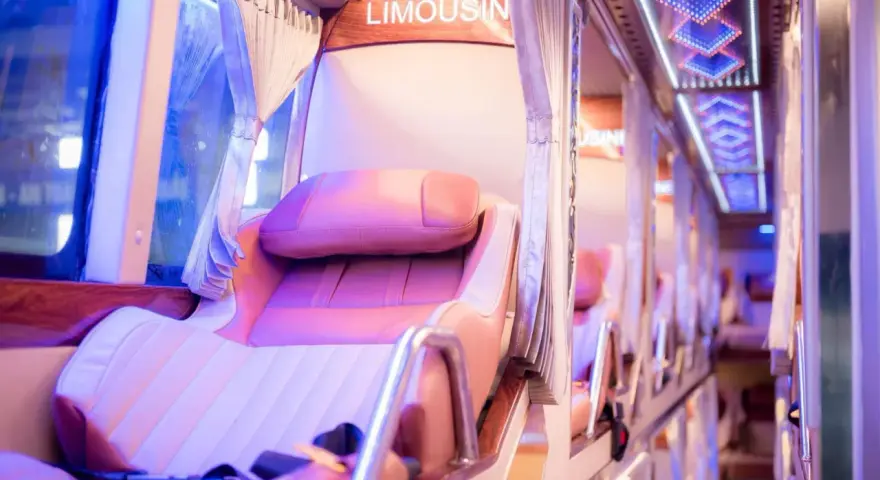 Intérieur d'un bus de luxe, avec des sièges confortables et un éclairage d'ambiance. Le mot "LIMOUSIN" est visible.
