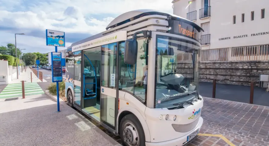 Un bus moderne, un trainbus, attend à un arrêt à Saint-Cyprien, prêt à emmener les passagers pour une transition écologique.