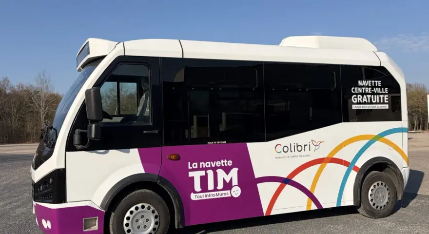 Le bus TIM, navette gratuite de Toul Intra-Muros, roule sous un ciel bleu.