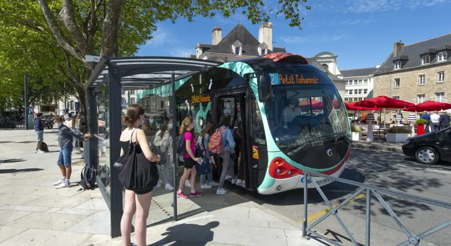 Un infobus à Vannes, avec des passagers montant à bord sous un ciel bleu.