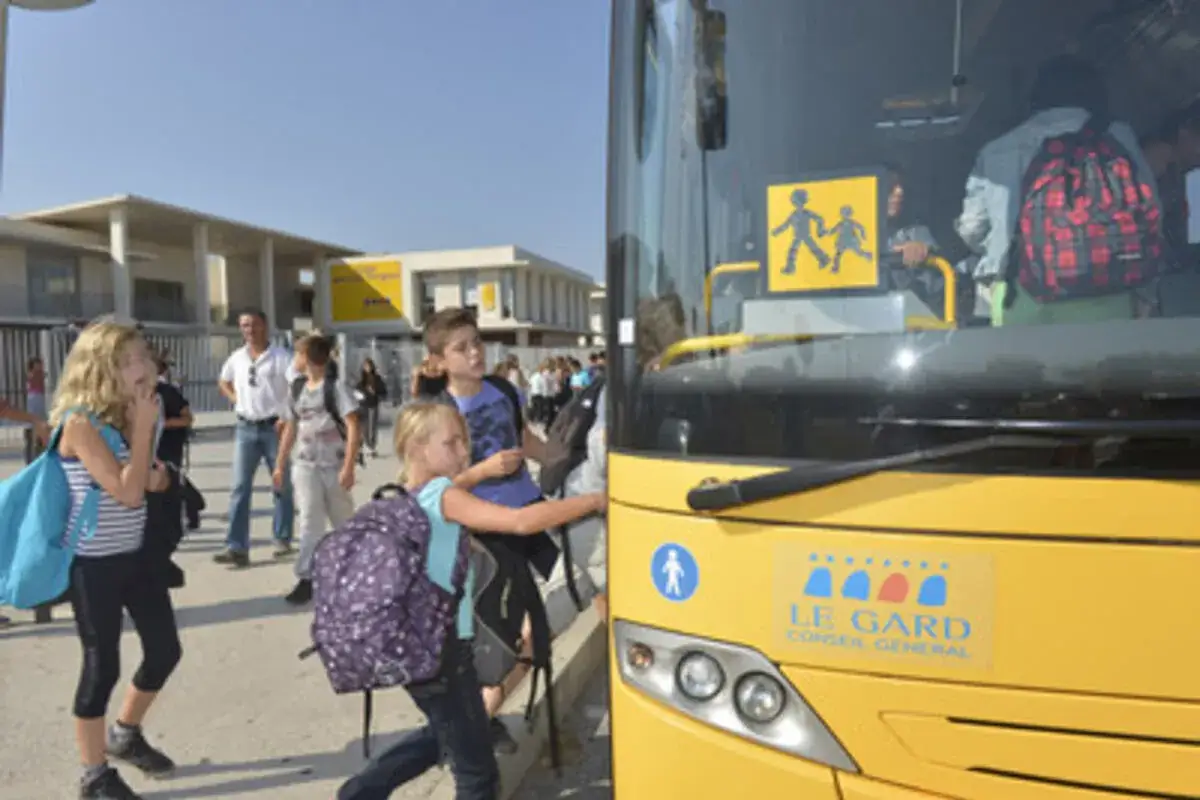 Des enfants montent dans un bus jaune, signe de l'obligation transport scolaire commune.