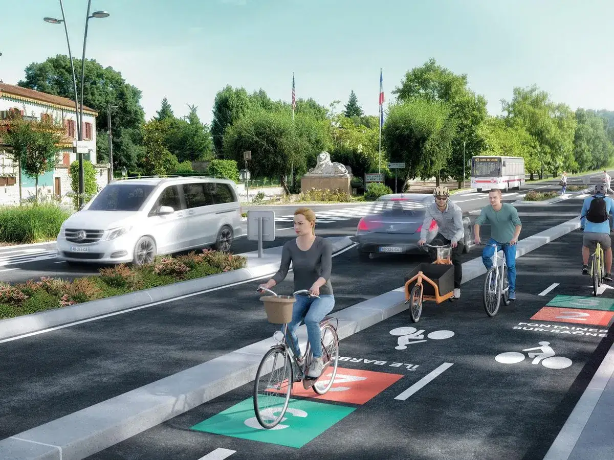 Des cyclistes et un bus profitent d'un am&eacute;nagement urbain favorisant le d&eacute;placement doux. Des pistes cyclables color&eacute;es et bien indiqu&eacute;es facilitent la circulation.