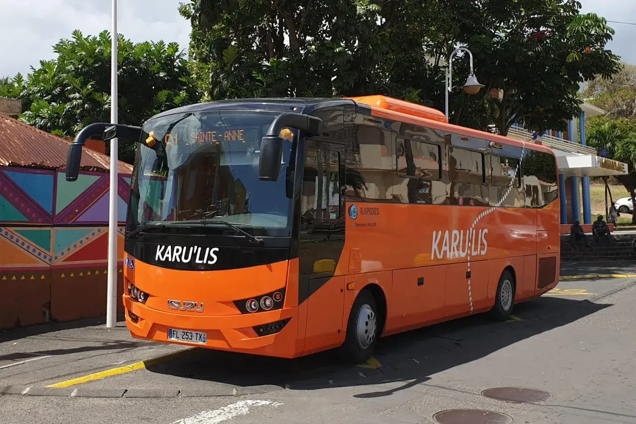 Bus Karu'lis orange vif, direction Sainte-Anne, en Guadeloupe. Un transport pratique pour explorer l'île.