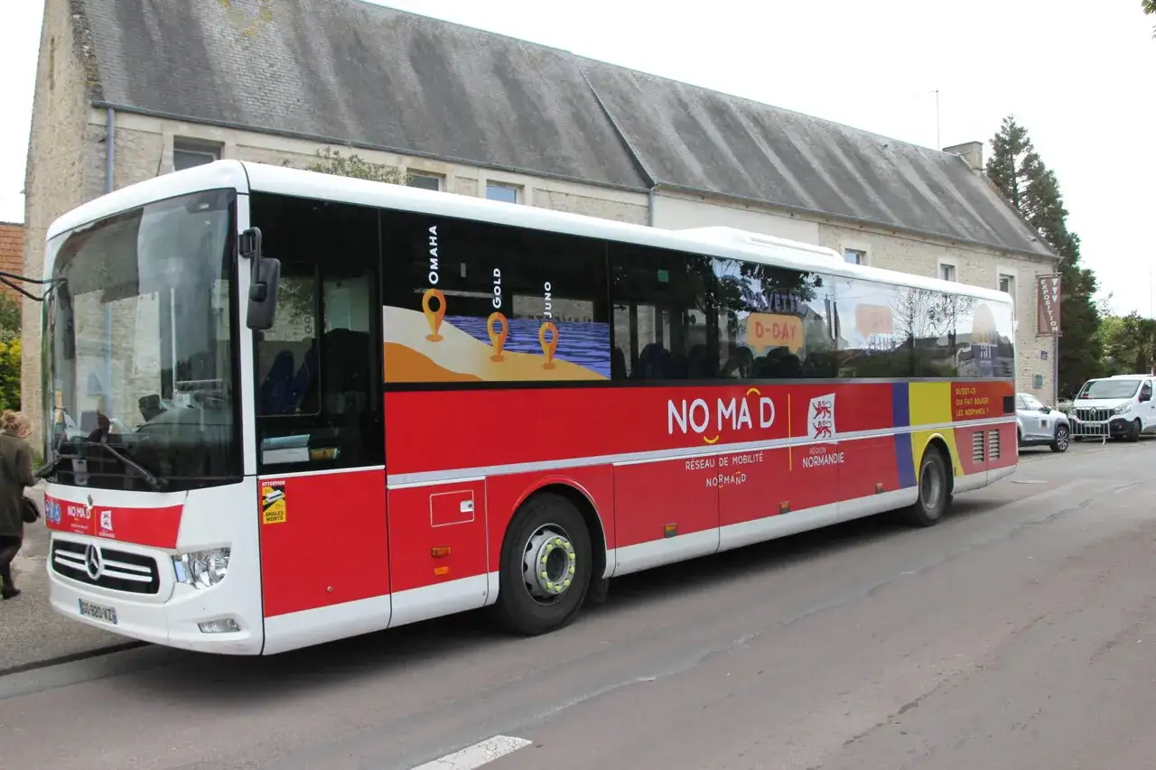 Bus NOMAD rouge et blanc, desservant les plages du débarquement, OMAHA, GOLD, JUNO, D-DAY. Un bus touristique à Bayeux.