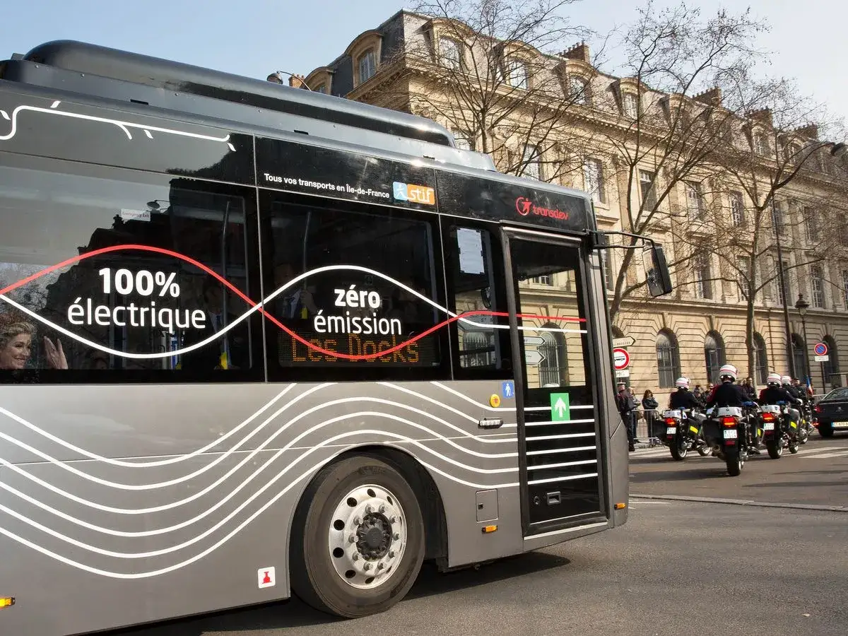 Un bus Ebusco 100% électrique et zéro émission circule à Cléon, escorté par des motards de police.
