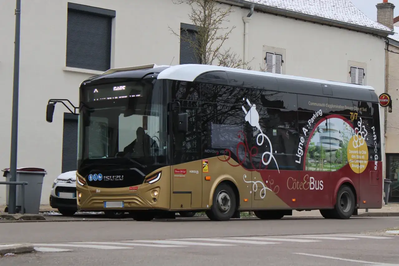 Un bus Côte&Bus de Beaune, ligne A, stationne près d'un bâtiment. Il arbore des motifs stylisés et une image du Palais des Congrès de Beaune.