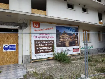 Panneau "Prochainement résidence Les terrasses fleuries" sur un bâtiment en démolition, signe de spéculation foncière.