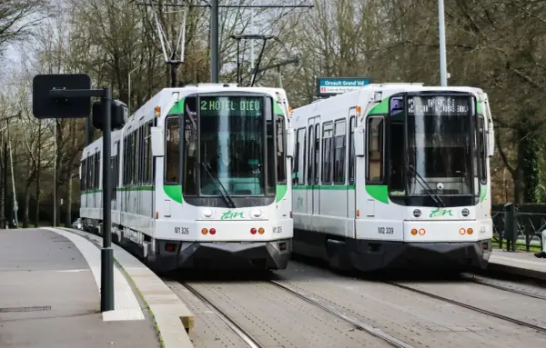 Deux trams blancs et verts de la Tan à Nantes, prêts à offrir un transport nantes gratuit. Ligne 2 vers Hôtel Dieu et Orvault Grand Val.