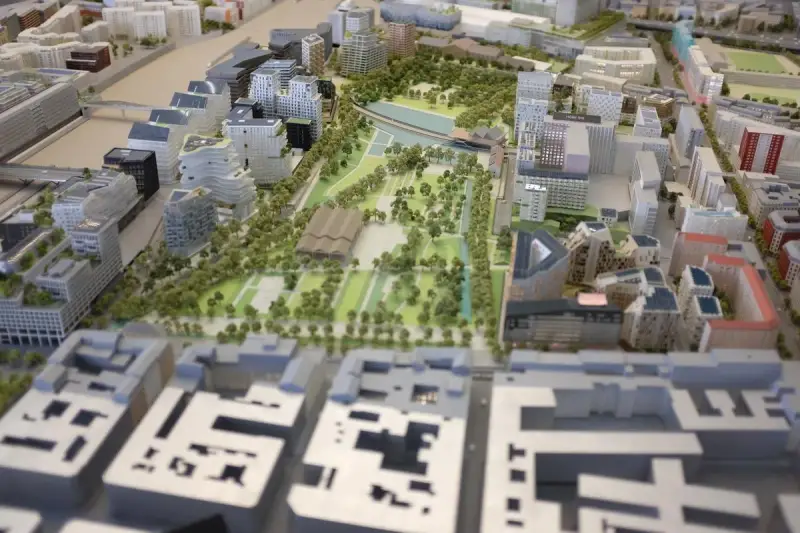 Maquette d'une opération d'aménagement urbain avec bâtiments modernes, espaces verts et un plan d'eau.